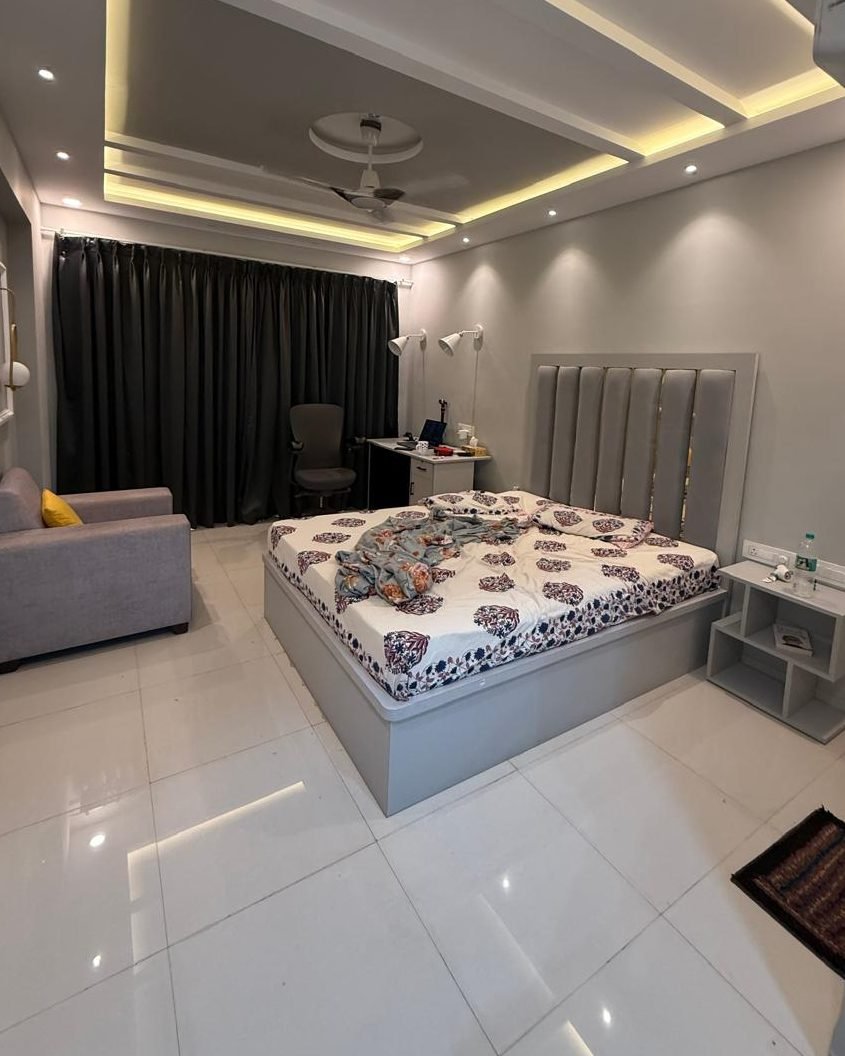 Bedroom with cove lighting and seating